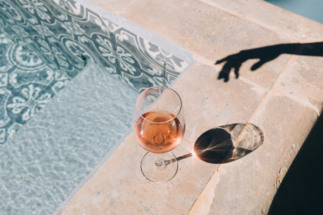 Glass of Wine and Hand Shadow by the Swimming Pool