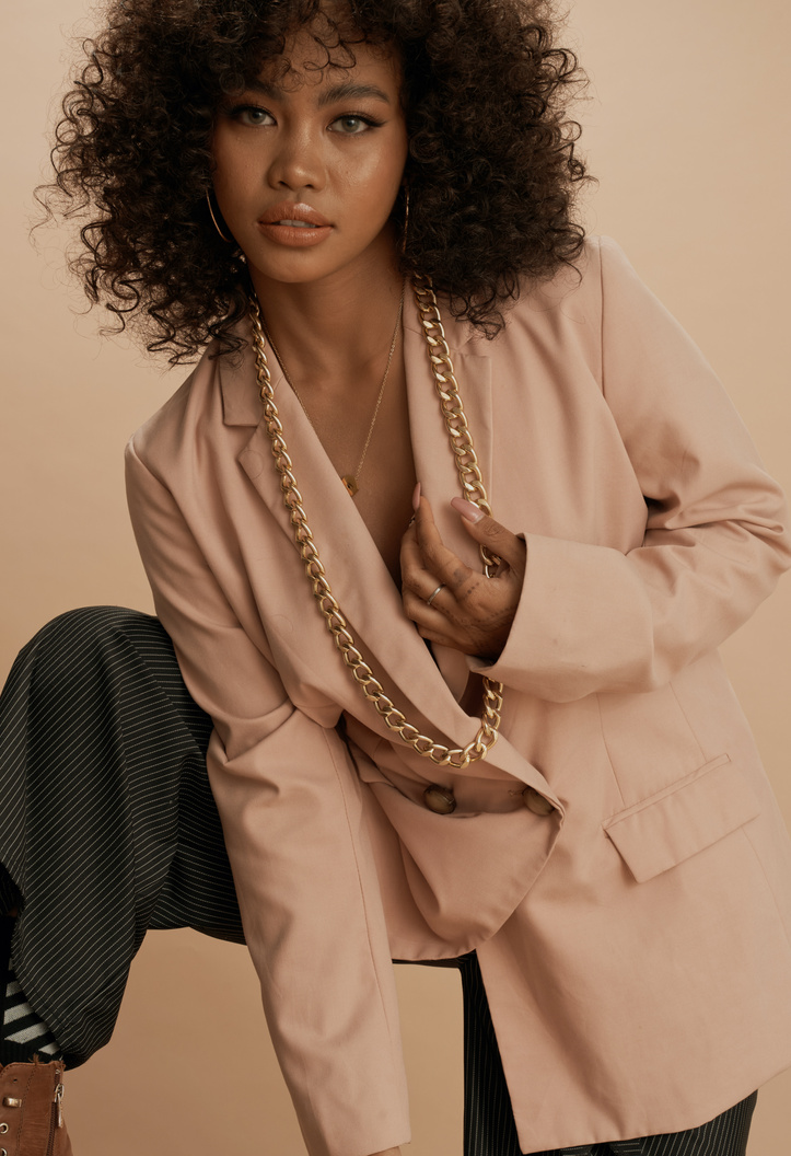 Curly-Haired Woman Wearing a Beige Suit Jacket